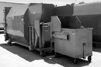 Rear feed cart dumper on a self-contained compactor